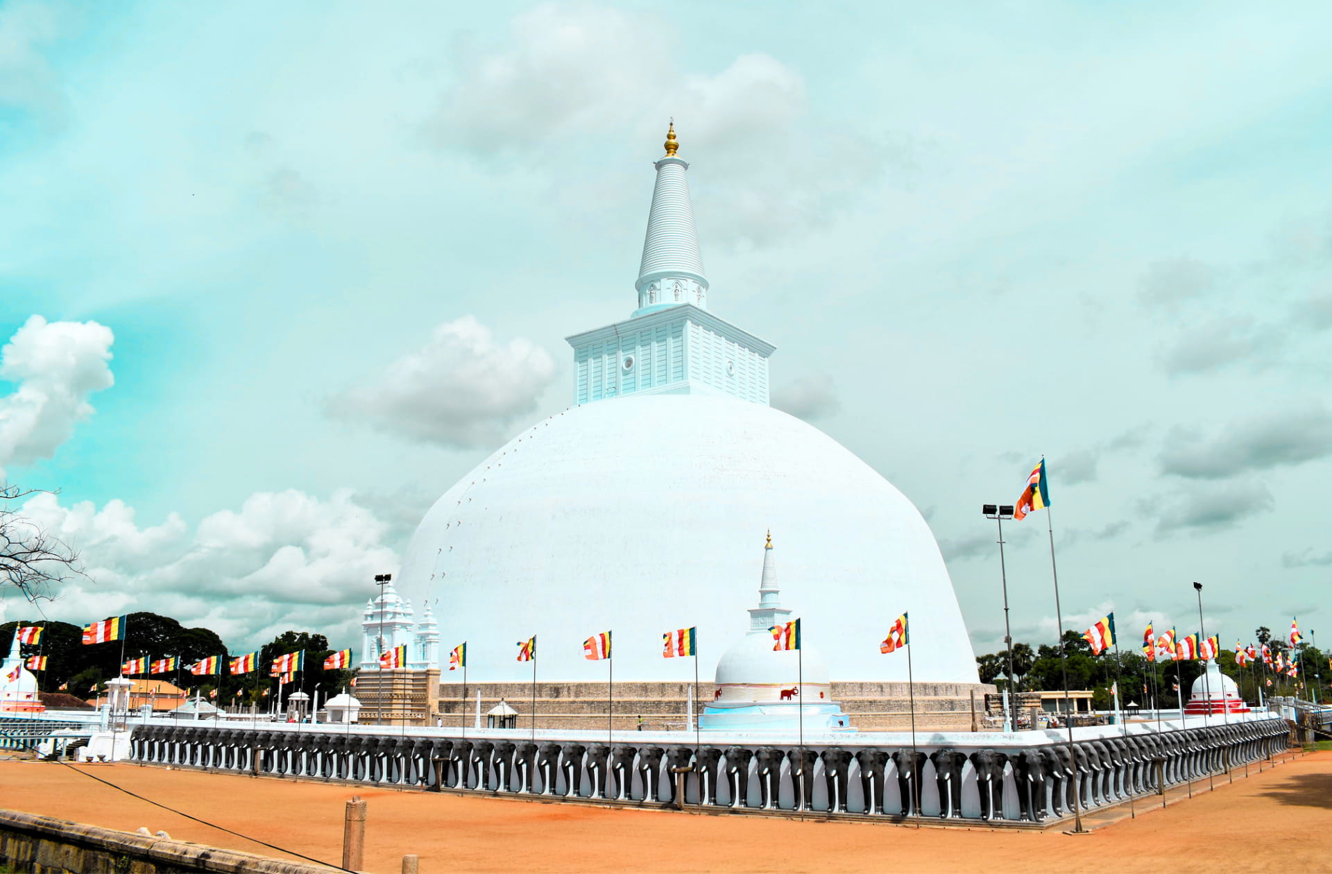 The massive white dome and carved elephant wall of Ruwanwelisaya stupa in Anuradhapura, Sri Lanka